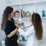Pediatra examinando bebê com estetoscópio em consulta de rotina na clínica Por Trás das Letras, em Moema
